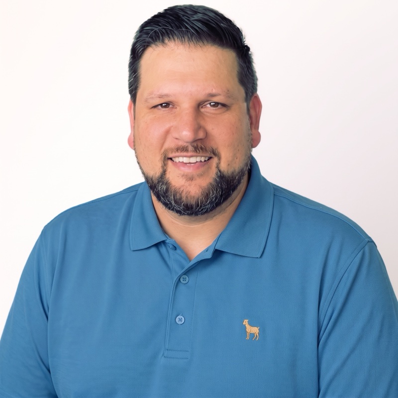 Dustin Scott Garza, developer and business manager, smiling in a blue polo